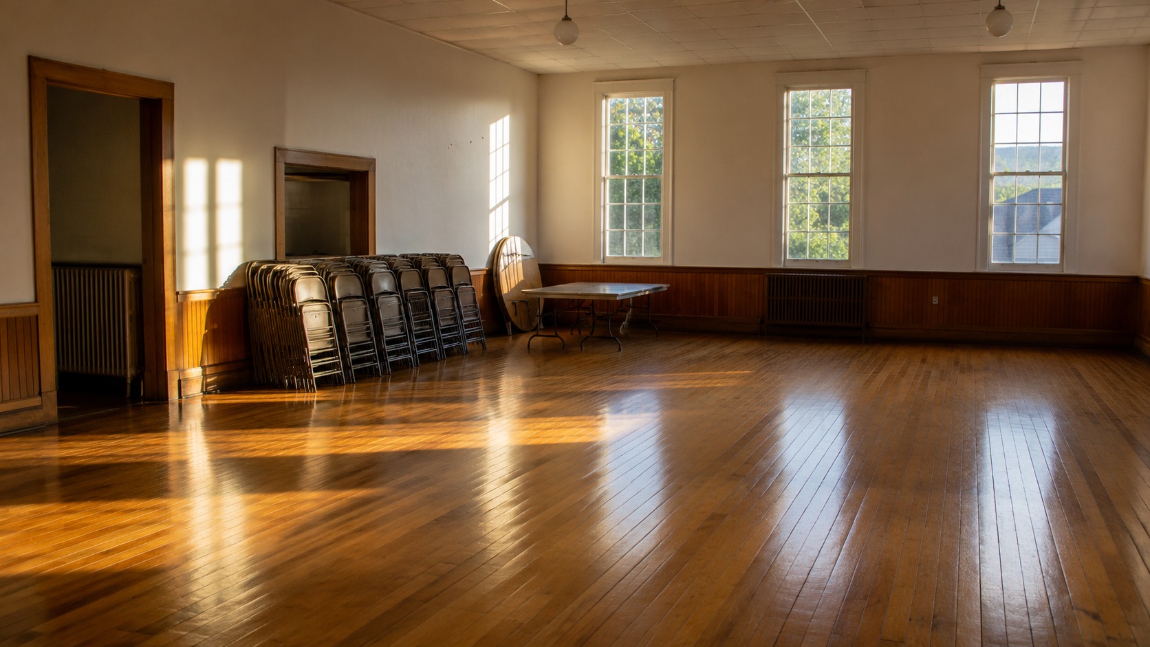 Older event hall with original hardwood floors being prepared for an event install