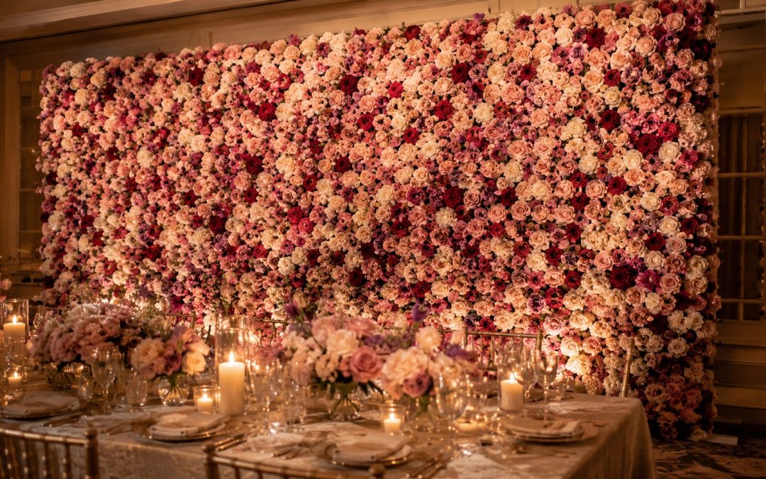 Dense mixed colour floral wall standing behind a styled table at a Hamilton reception