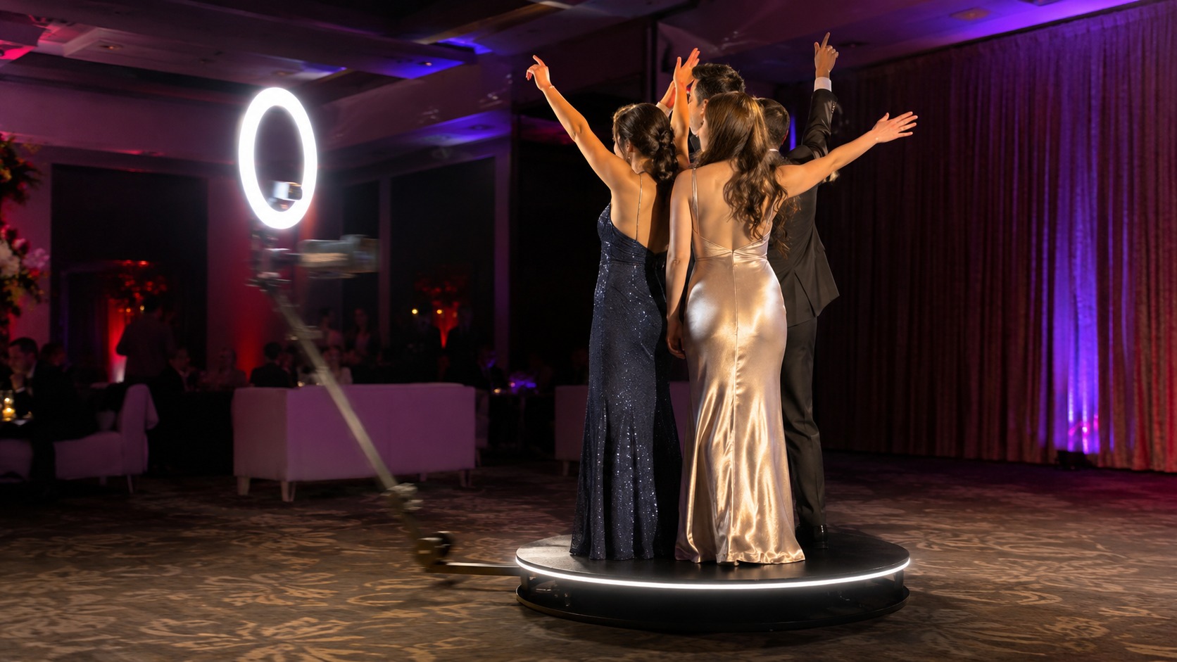 Guests standing on a 360 video booth platform as the camera arm sweeps around them