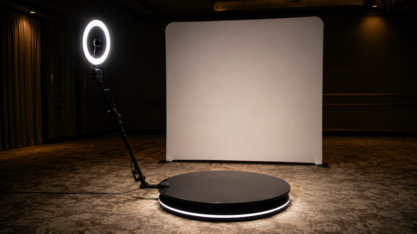 360 booth ring light illuminating a platform with a lit backdrop behind it