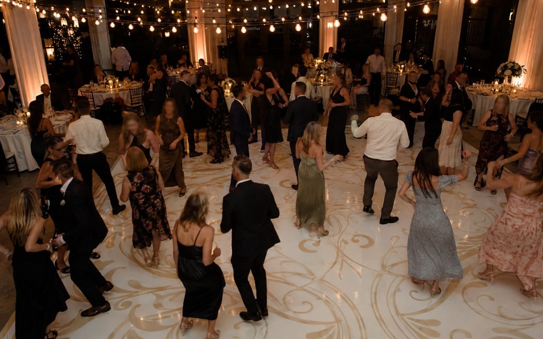 Guests dancing on a custom wrapped vinyl dance floor at an evening reception