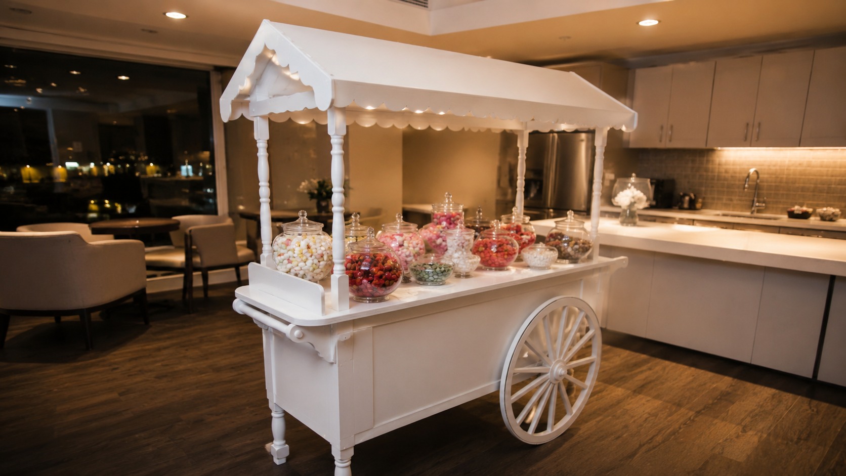 Candy cart set up in a small condominium party room with a kitchenette behind