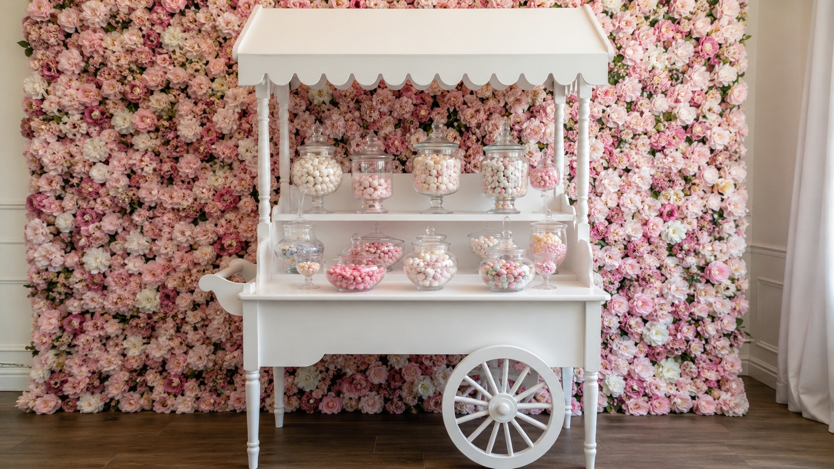 Candy cart positioned in front of a full floral wall backdrop at an indoor event